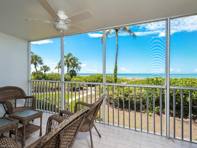 sunroom / solarium with a water view, a healthy amount of sunlight, and ceiling fan