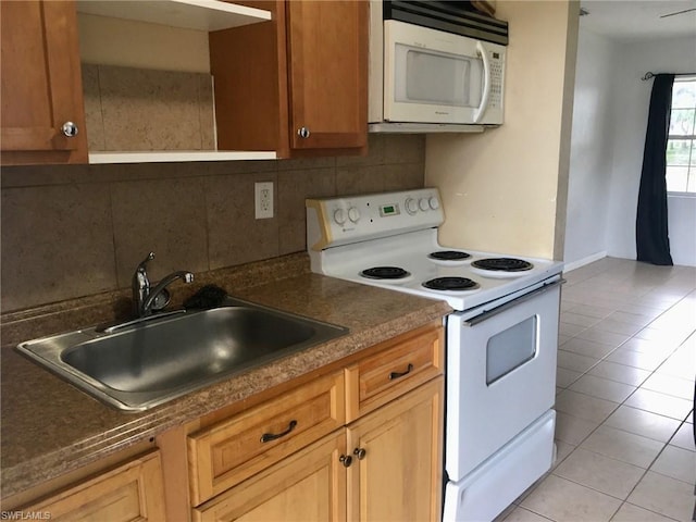 kitchen with backsplash, white appliances, sink, and light tile floors