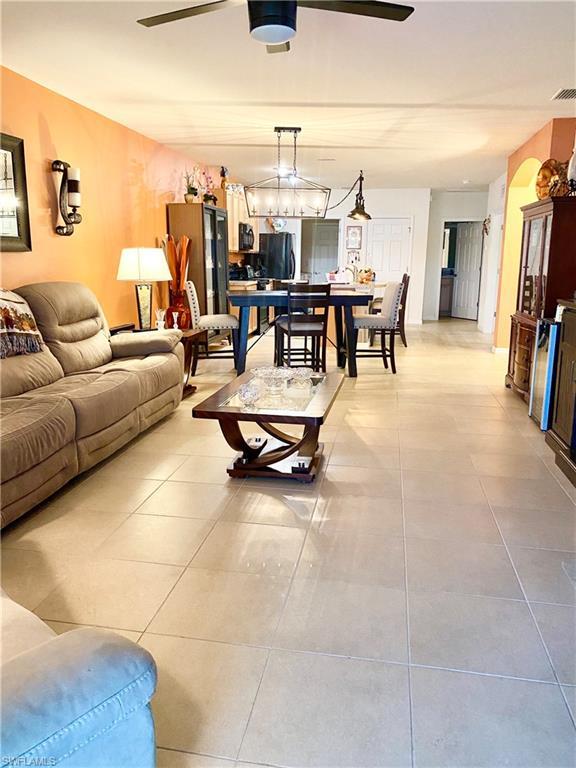 tiled living room with ceiling fan