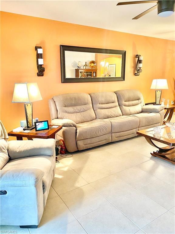 living room featuring light tile flooring and ceiling fan