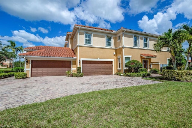 mediterranean / spanish home with a front lawn and a garage