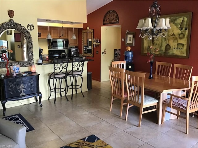 dining area featuring a chandelier, light tile floors, and high vaulted ceiling