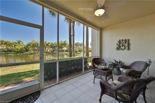 sunroom / solarium featuring plenty of natural light, ceiling fan, and a water view