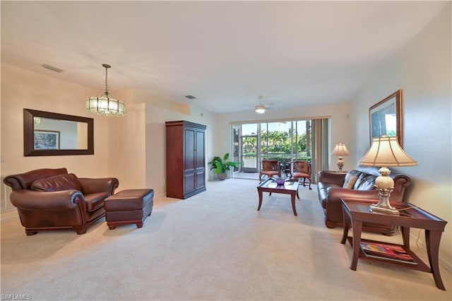 carpeted living room with ceiling fan with notable chandelier