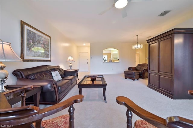 living room with light carpet and ceiling fan with notable chandelier