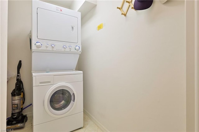 laundry room featuring light tile flooring and stacked washing maching and dryer