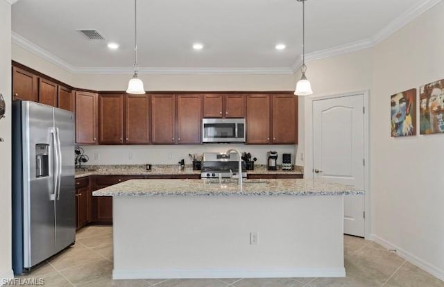 kitchen with appliances with stainless steel finishes, decorative light fixtures, light stone countertops, and a kitchen island with sink