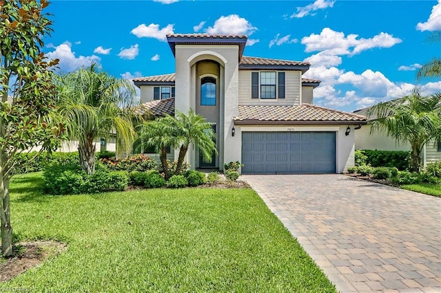 mediterranean / spanish house with a front lawn and a garage