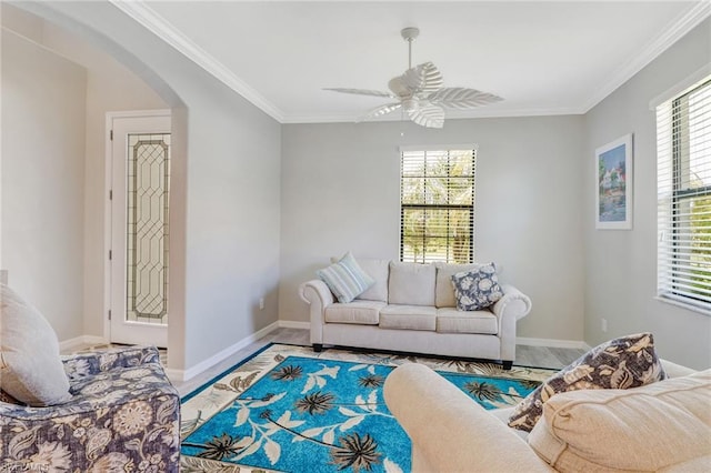 living room with crown molding, ceiling fan, and a wealth of natural light