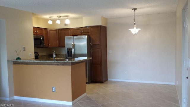 kitchen featuring kitchen peninsula, light tile flooring, appliances with stainless steel finishes, track lighting, and pendant lighting