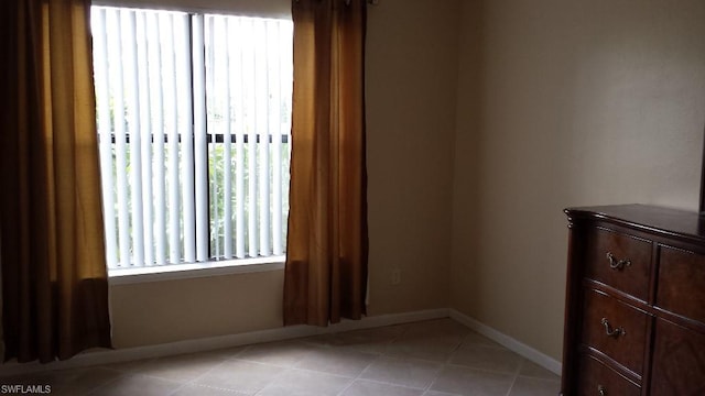 unfurnished room with plenty of natural light and light tile flooring