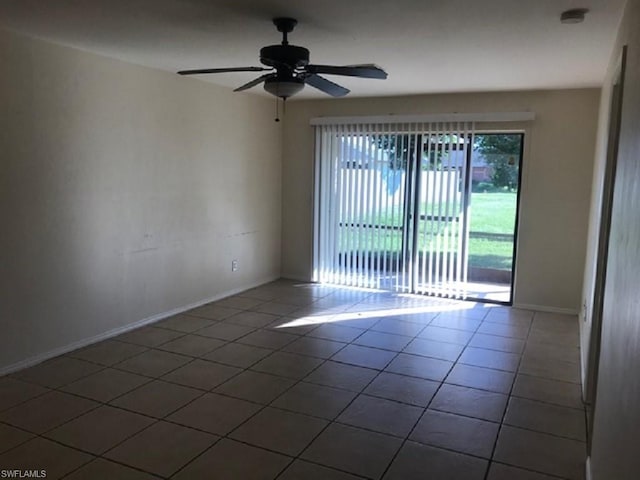 spare room featuring dark tile floors and ceiling fan