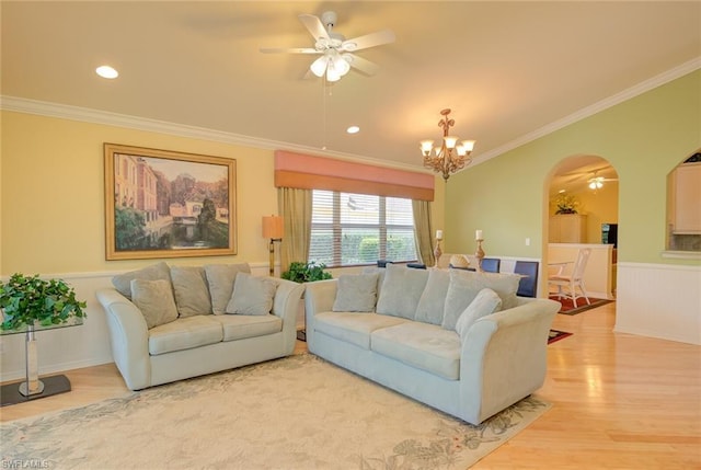 living room featuring light hardwood / wood-style floors, ceiling fan with notable chandelier, and crown molding