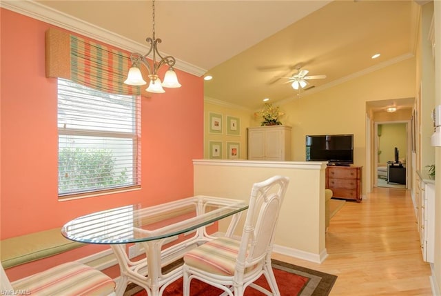 dining space featuring ornamental molding, vaulted ceiling, light hardwood / wood-style flooring, and ceiling fan with notable chandelier