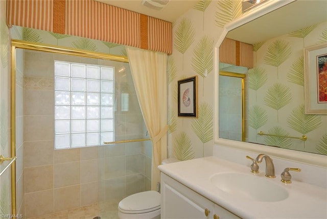 bathroom featuring a shower with shower door, toilet, a healthy amount of sunlight, and large vanity