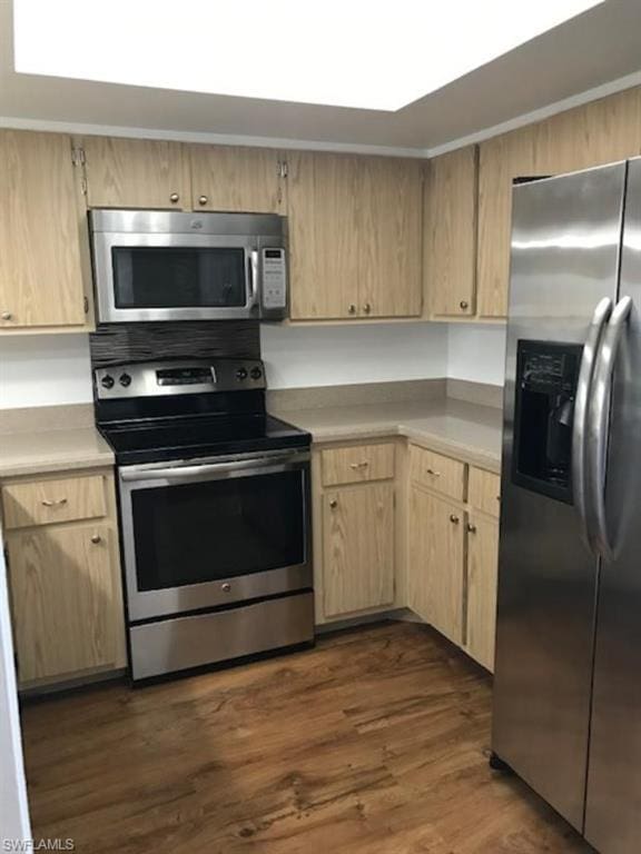 kitchen with dark hardwood / wood-style floors, stainless steel appliances, and light brown cabinets