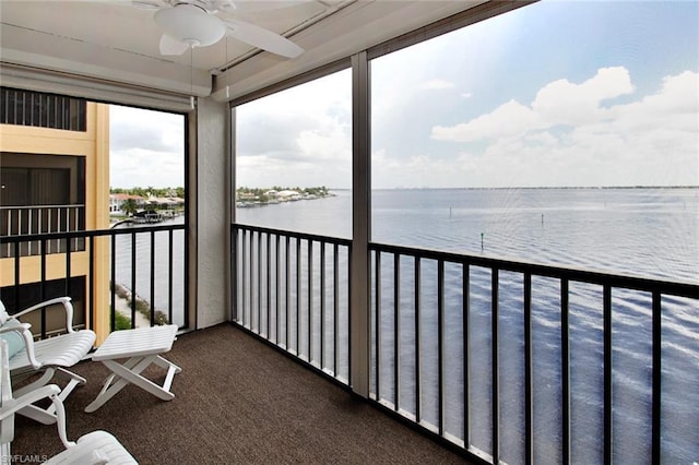 balcony featuring ceiling fan and a water view