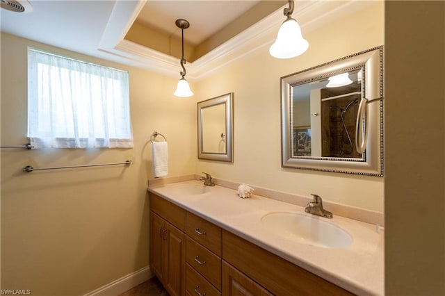 bathroom featuring double sink, large vanity, and a raised ceiling