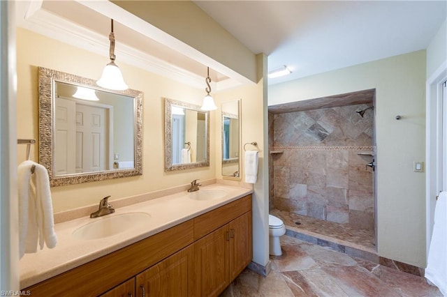 bathroom with toilet, large vanity, dual sinks, tile floors, and a tile shower