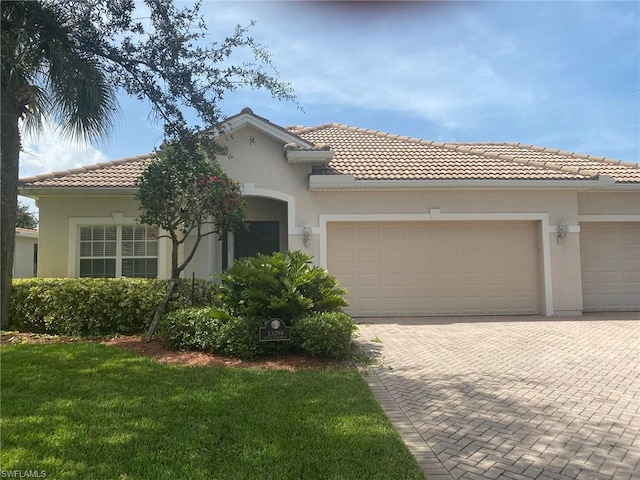 mediterranean / spanish-style home with a front lawn and a garage