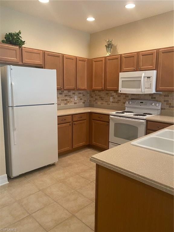 kitchen with white appliances, sink, tasteful backsplash, and light tile flooring