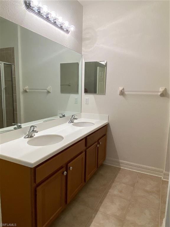 bathroom with tile flooring, oversized vanity, and dual sinks