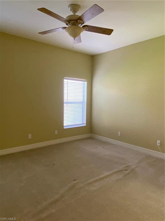 spare room featuring ceiling fan and light colored carpet