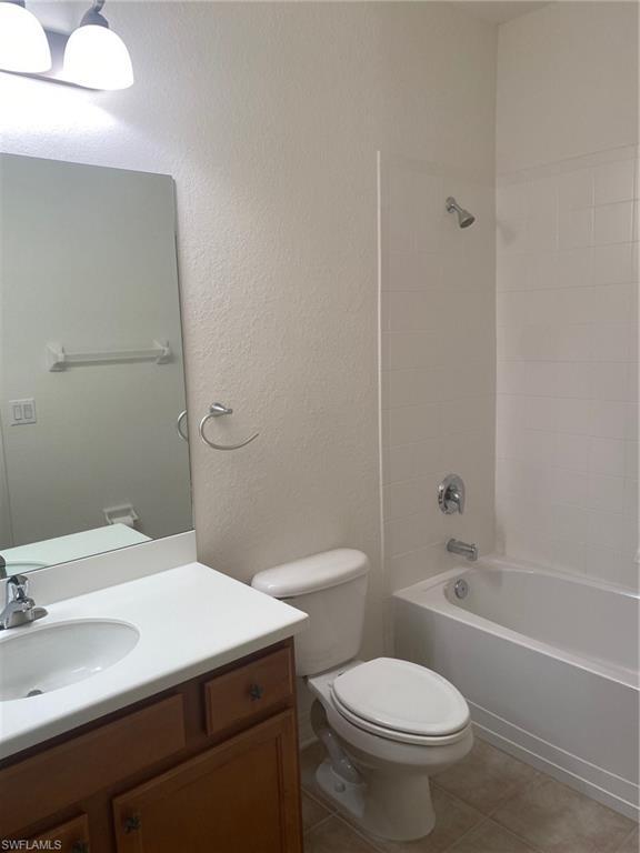 full bathroom featuring toilet, bathtub / shower combination, tile flooring, and vanity