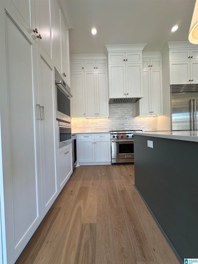 kitchen featuring white cabinetry, wine cooler, backsplash, high end appliances, and light hardwood / wood-style flooring