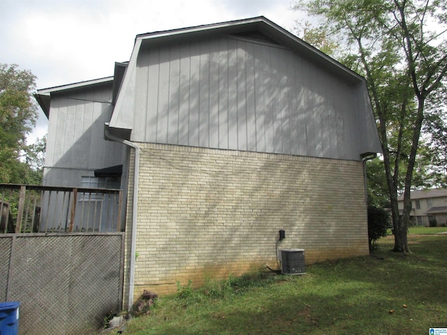 view of side of home with a lawn and central AC