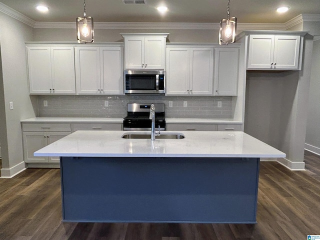 kitchen featuring a kitchen island with sink, white cabinetry, stainless steel appliances, and hanging light fixtures