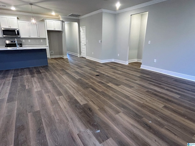 kitchen featuring dark hardwood / wood-style floors, ornamental molding, and appliances with stainless steel finishes