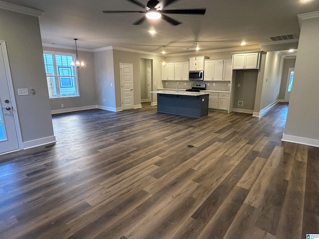 kitchen featuring dark hardwood / wood-style floors, crown molding, a kitchen island with sink, white cabinets, and appliances with stainless steel finishes