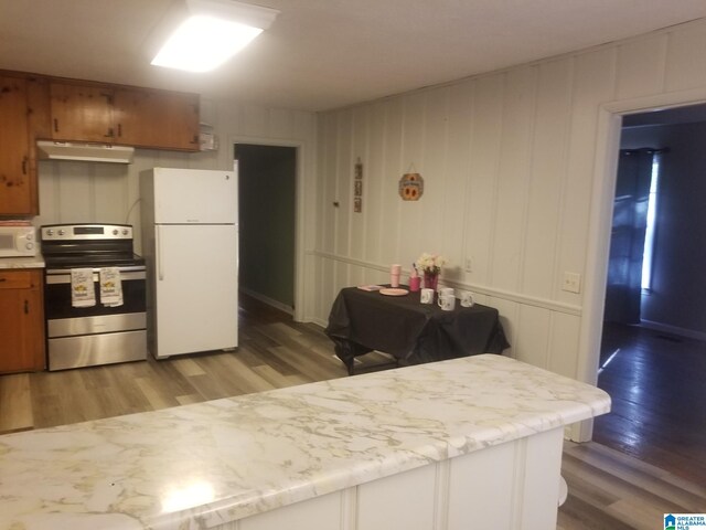 kitchen with white appliances and hardwood / wood-style flooring