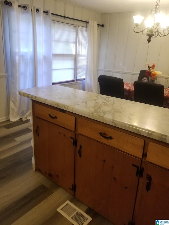 kitchen with a notable chandelier, dark wood-type flooring, and pendant lighting