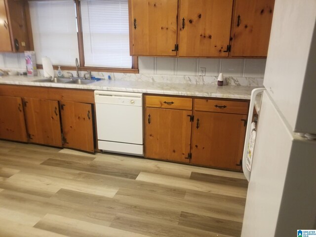 kitchen with light hardwood / wood-style floors, white appliances, and sink