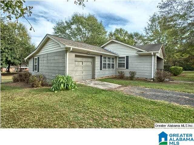 ranch-style house with a front yard and a garage