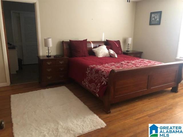 bedroom with dark hardwood / wood-style floors