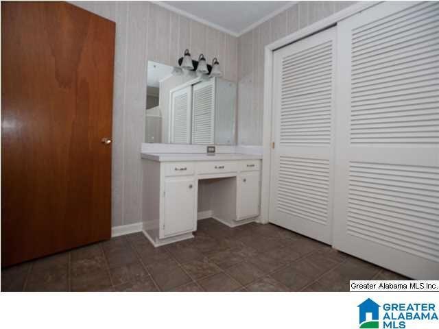 bathroom with tile flooring and crown molding