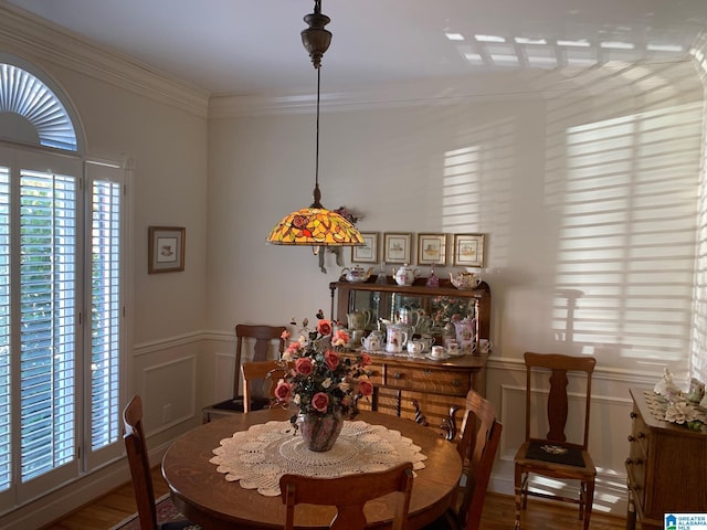 dining space with plenty of natural light, hardwood / wood-style floors, and crown molding