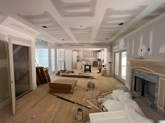 interior space with light hardwood / wood-style flooring, french doors, and a fireplace