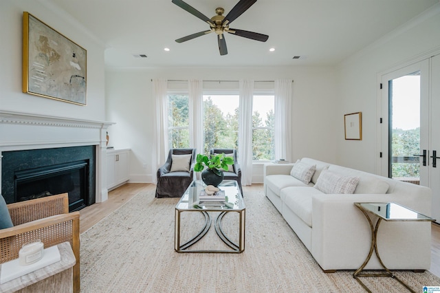 living room with crown molding, french doors, ceiling fan, and light wood-type flooring