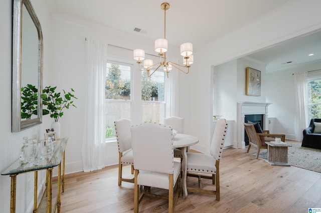 dining area with a chandelier, light wood-type flooring, and a wealth of natural light