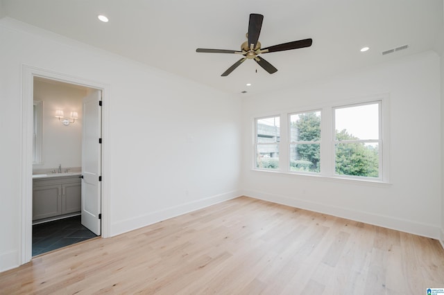 spare room with sink, ornamental molding, ceiling fan, and light wood-type flooring