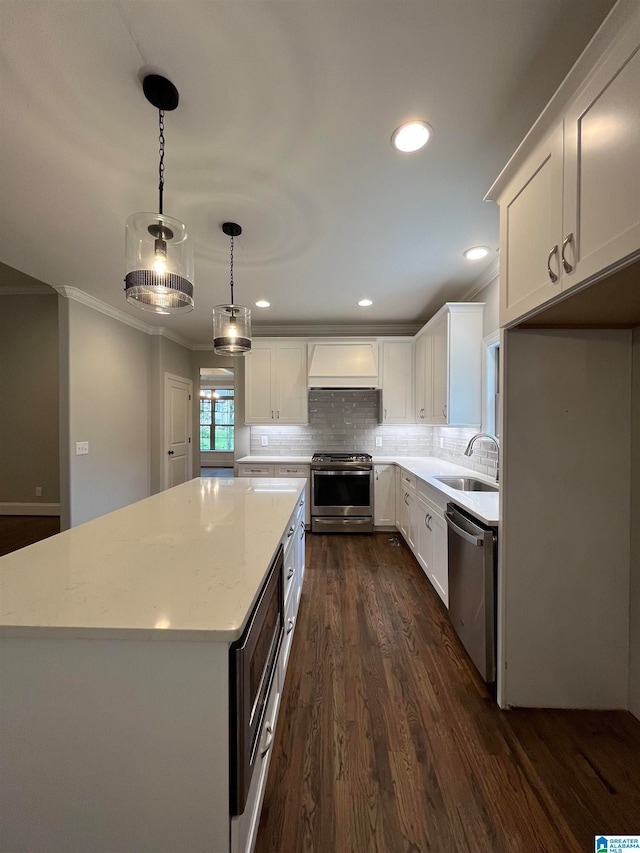 kitchen with white cabinetry, sink, hanging light fixtures, and appliances with stainless steel finishes