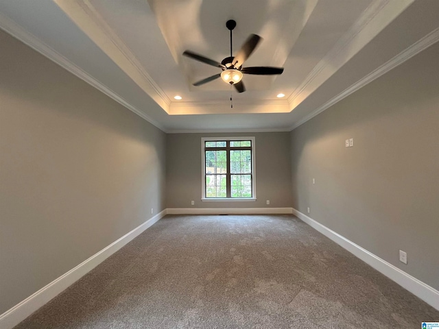 carpeted empty room with ceiling fan, a raised ceiling, and crown molding