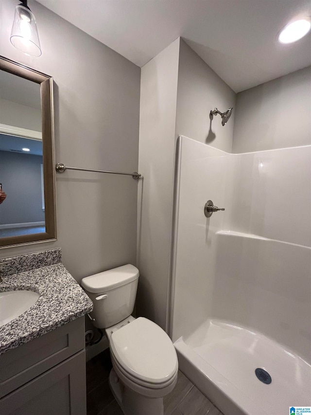 bathroom with a shower, vanity, and toilet