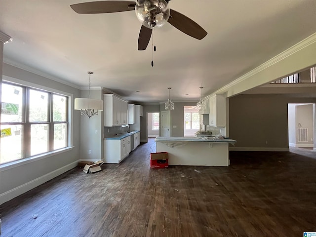 kitchen featuring ornamental molding, ceiling fan, pendant lighting, dark hardwood / wood-style floors, and white cabinetry