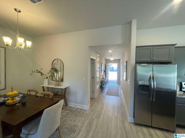 dining space featuring an inviting chandelier and light hardwood / wood-style flooring