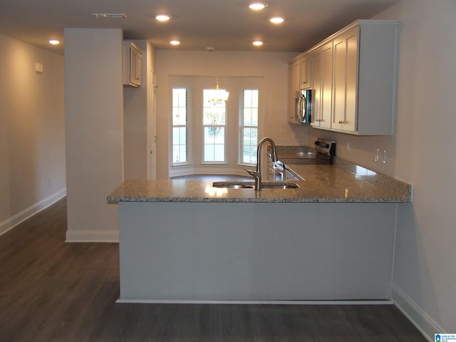 kitchen featuring dark hardwood / wood-style floors, kitchen peninsula, stainless steel appliances, and stone countertops